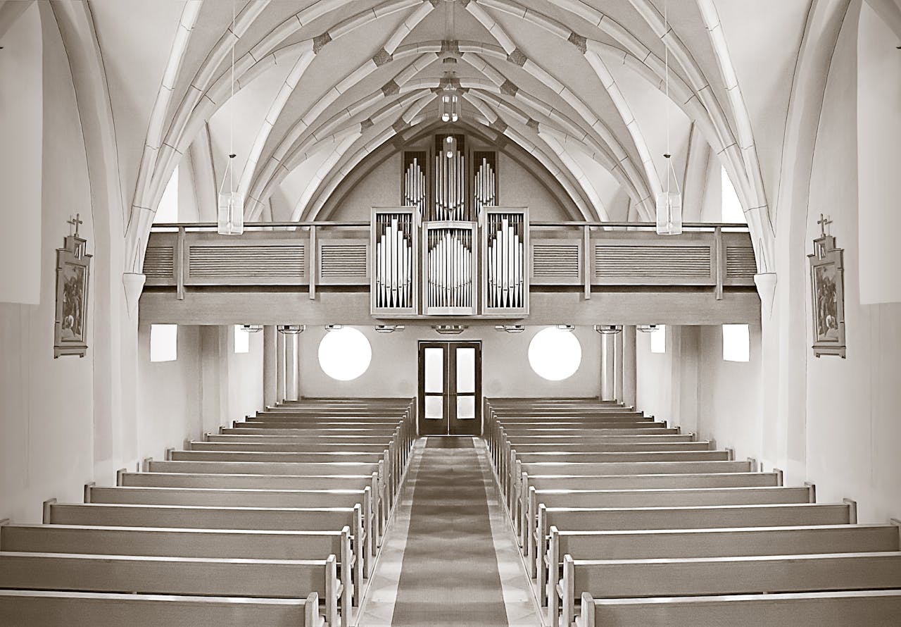 Symmetrical church interior highlighting architectural details and organ pipes.