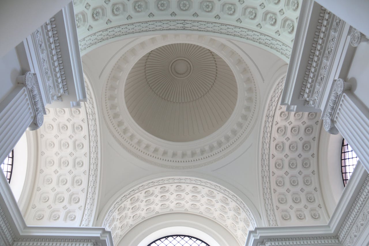 A stunning view of an ornate white dome ceiling with intricate architectural details.